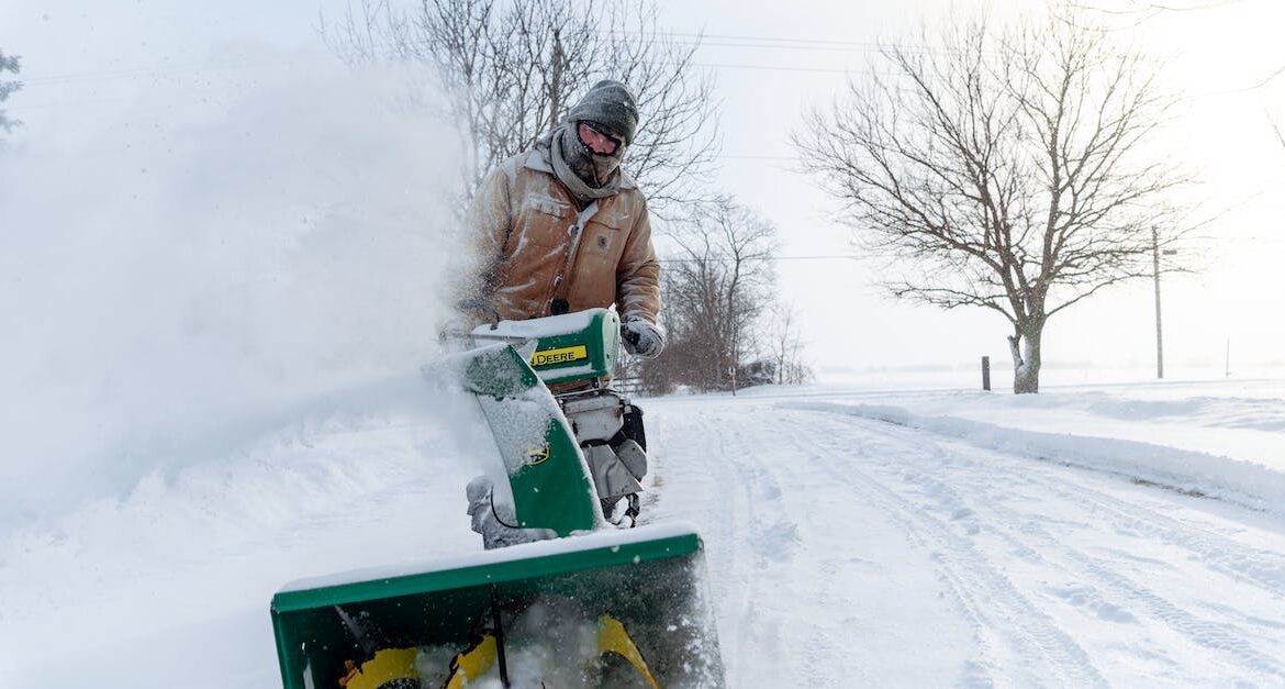 man pushing snowblower