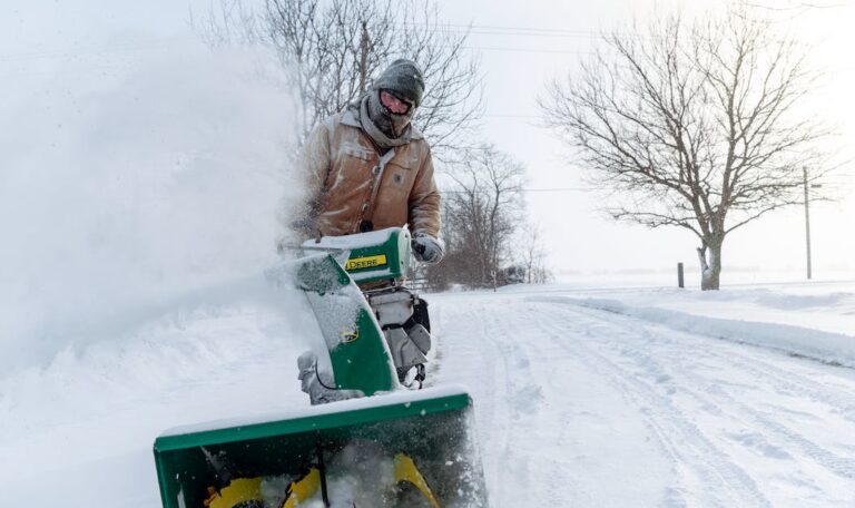 man pushing snowblower